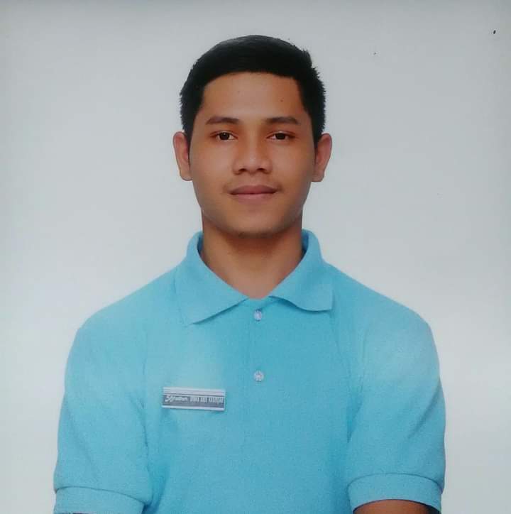 Foto profesional saya dengan latar belakang biru muda, mengenakan kemeja formal dan tersenyum ramah